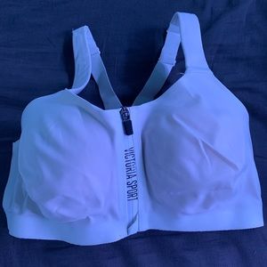 It is a white sports bra with a zipper and  clasps
